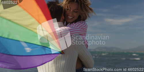 Image of Happy couple having fun with kite on beach