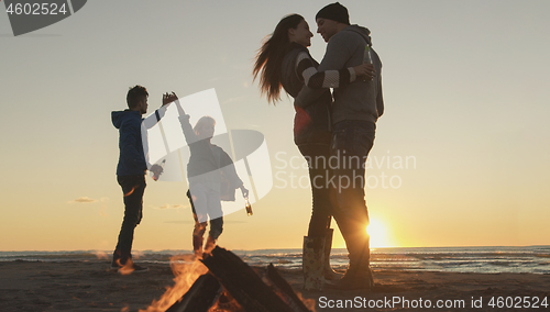 Image of Friends having fun at beach on autumn day