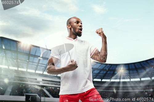 Image of The football player in motion on the field of stadium