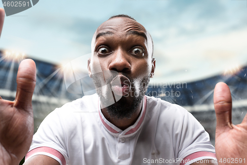 Image of The football player in motion on the field of stadium