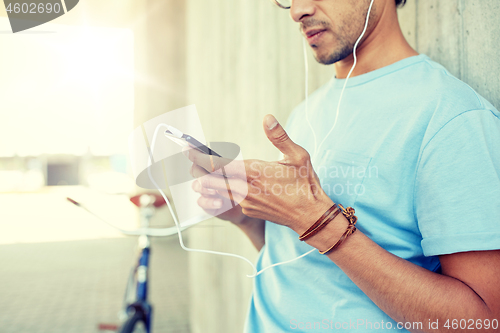 Image of man with earphones and smartphone listening music