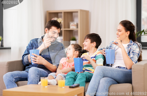 Image of happy family with popcorn watching tv at home