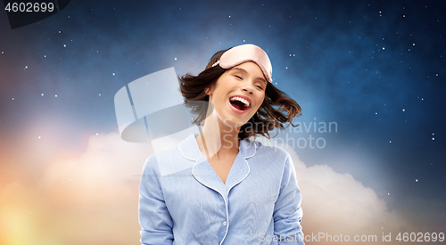 Image of happy young woman in pajama and eye sleeping mask