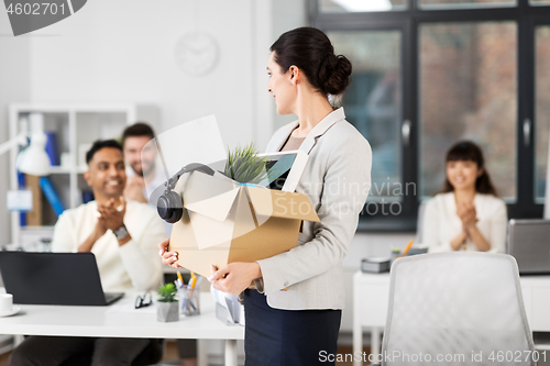 Image of happy female office worker with personal stuff