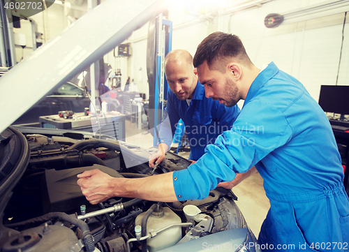 Image of mechanic men with wrench repairing car at workshop