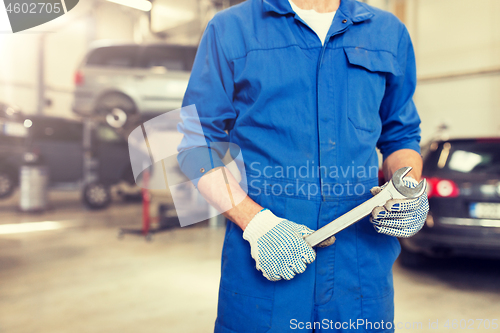 Image of auto mechanic or smith with wrench at car workshop