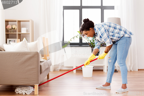 Image of african woman or housewife cleaning floor at home