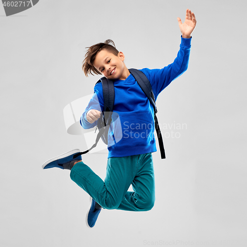 Image of happy smiling student boy with school bag jumping