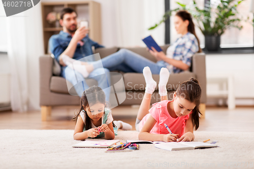 Image of happy sisters drawing in sketchbooks at home