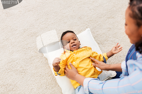 Image of african american mother with happy baby at home