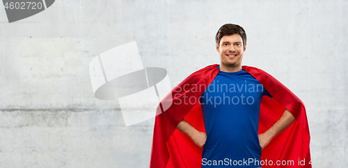 Image of man in red superhero cape over concrete background