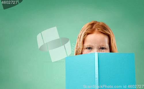 Image of red student girl with book over school chalk board