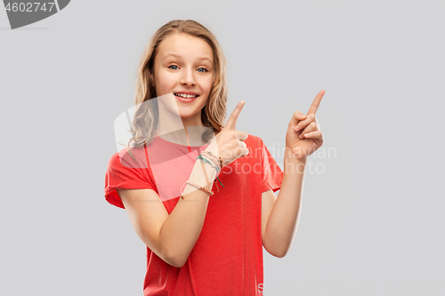 Image of smiling teenage girl pointing fingers to something