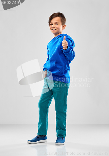 Image of smiling boy in blue hoodie showing thumbs up
