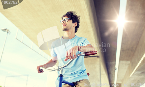 Image of young hipster man riding fixed gear bike