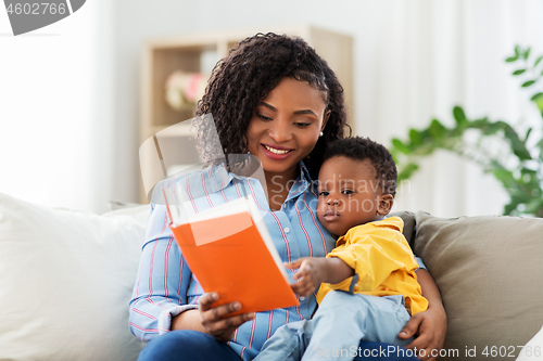 Image of african american mother with book and baby at home