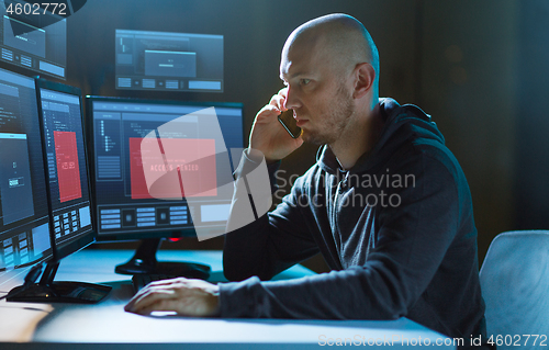 Image of hacker with no access on computer calls on cell