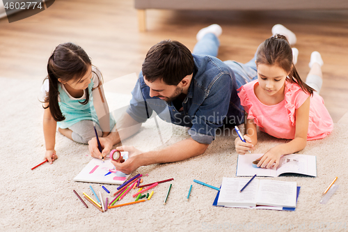 Image of father with little daughters drawing at home