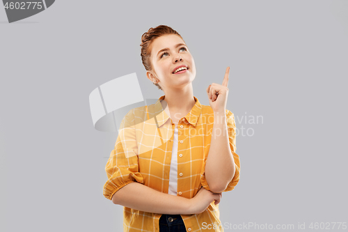 Image of red haired teenage girl pointing finger up