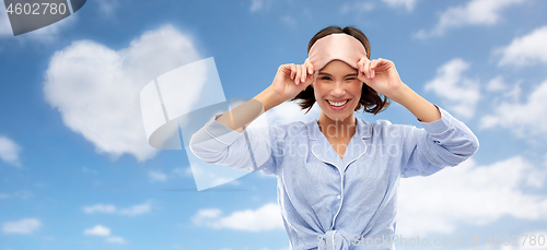 Image of happy young woman in pajama and eye sleeping mask