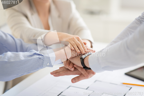 Image of close up of business team stacking hands