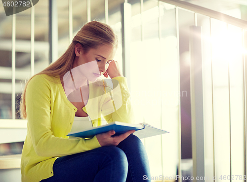 Image of high school student girl reading book on stairs