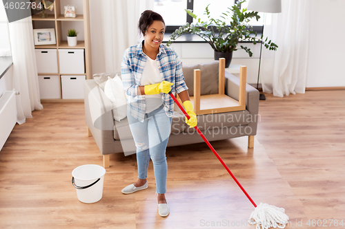 Image of african woman or housewife cleaning floor at home