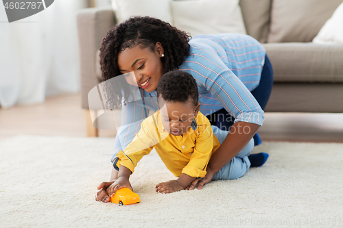 Image of mother and baby playing with toy car at home