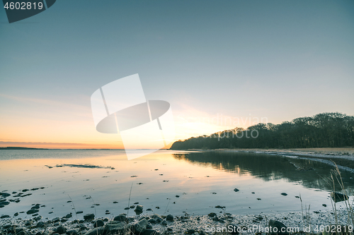 Image of Lake in the sunrise with rocks on the beach