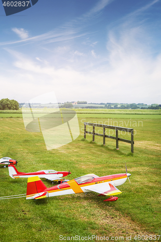 Image of Model airplanes ona line on a green field