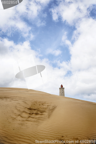 Image of Lighthouse rising up behind a sand dune