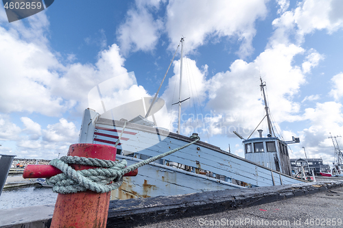 Image of Fishing boat in a Scandinavian harbor in retro blue