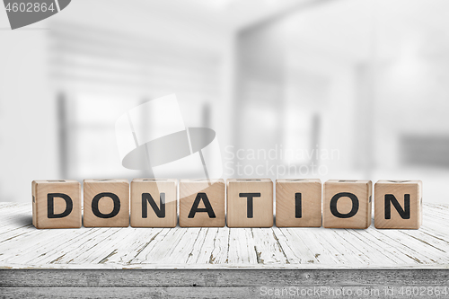 Image of Wooden donation sign on a worn desk