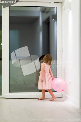 Image of cute little girl playing with balloons