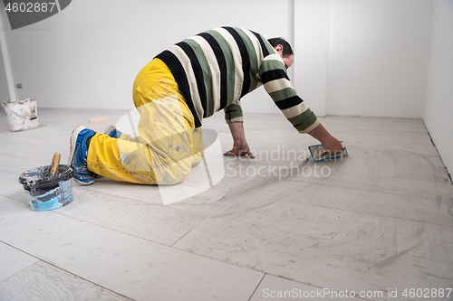 Image of Tilers filling the space between ceramic wood effect tiles