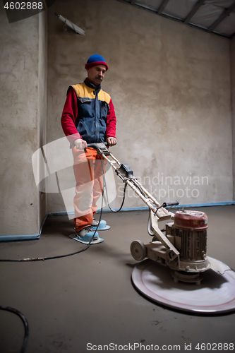 Image of worker performing and polishing sand and cement screed floor