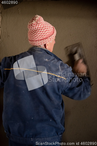 Image of Worker plastering the wall by concrete