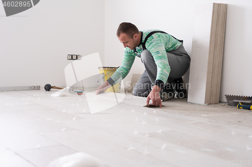 Image of worker installing the ceramic wood effect tiles on the floor