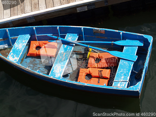 Image of blue row boat with orange life vests at dock