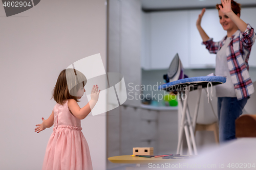 Image of mother and little daughter spending time together at home