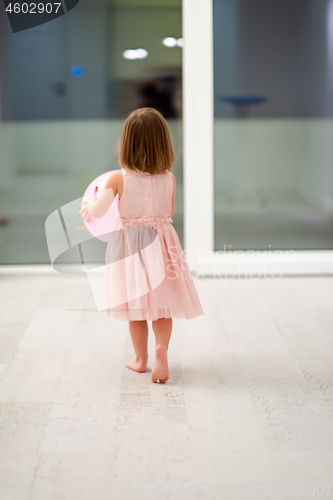 Image of cute little girl playing with balloons