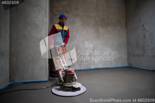 Image of worker performing and polishing sand and cement screed floor