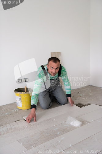 Image of worker installing the ceramic wood effect tiles on the floor