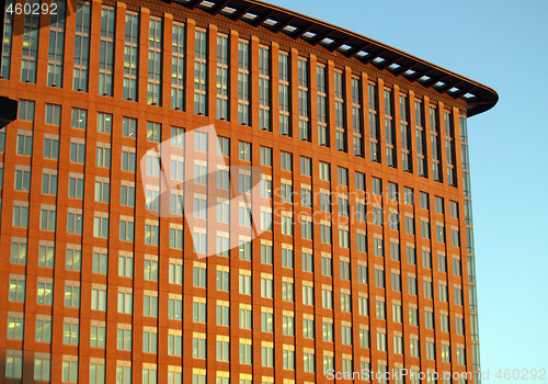 Image of red building with lots of windows in blue sky