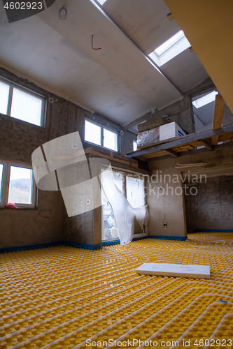 Image of yellow underfloor heating installation with white pipes