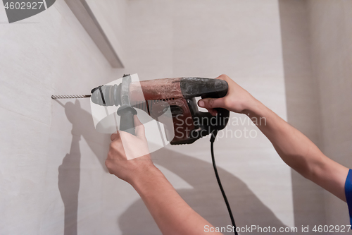 Image of construction worker drilling holes in the bathroom