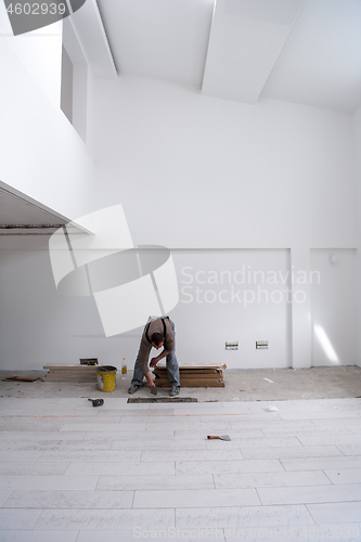 Image of worker installing the ceramic wood effect tiles on the floor