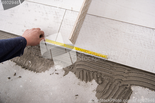 Image of worker installing the ceramic wood effect tiles on the floor