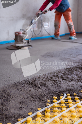 Image of worker performing and polishing sand and cement screed floor