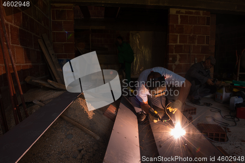 Image of welder with protective mask welding steel